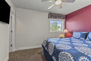 Carpeted bedroom featuring baseboards and ceiling fan