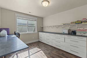 Bedroom or office space featuring dark wood-style floors and a textured ceiling