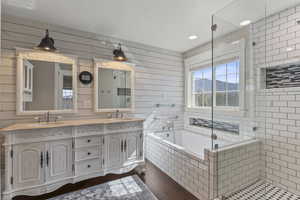 Primary bath with a shower stall, a bath, double vanity, dark wood-style floors, and recessed lighting