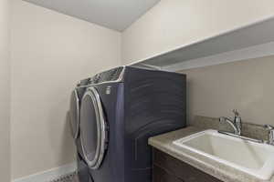 Laundry area with a sink and separate washer and dryer