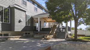 Back of house with a fire pit, stairway, covered deck.