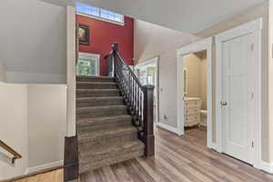 Stairs with wood finished floors and wallpapered walls