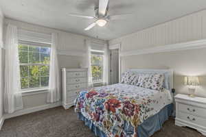 Bedroom featuring dark colored carpet and a ceiling fan