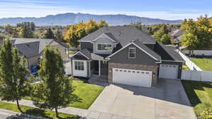 View of front of house with driveway, a mountain view, a residential view, roof with shingles, and an attached garage