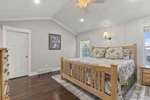 Primary bedroom featuring vaulted ceiling, dark wood-type flooring, recessed lighting, a ceiling fan, and ornamental molding