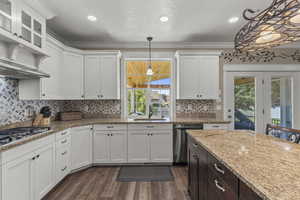 Kitchen with white cabinetry, crown molding, dark brown cabinetry, light stone counters, and recessed lighting