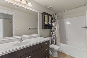 Bathroom with light tile patterned floors, vanity, and shower / bath combo