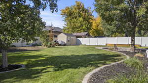 Fenced backyard with a storage shed and a patio area