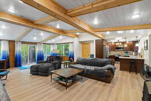 Living room with plenty of natural light, light wood-type flooring, and recessed lighting