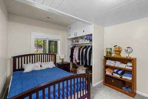 Bedroom with light colored carpet and a closet
