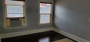 Spare room with dark wood finished floors and cooling unit