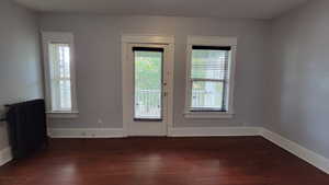 Entryway with radiator, healthy amount of natural light, and wood finished floors