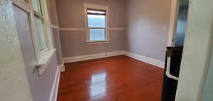 Empty room with baseboards and dark wood finished floors
