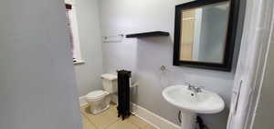 Bathroom with light tile patterned floors and a textured wall