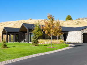 View of front of house featuring a standing seam roof, a metal roof, and stone siding