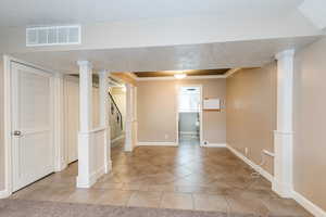 Main dining area with tile patterned flooring, crown molding, stairs, and a textured ceiling