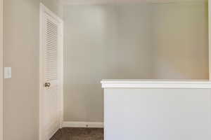 Corridor featuring baseboards and carpet flooring