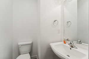 Half bath featuring a sink and toilet. Off Mud  Room