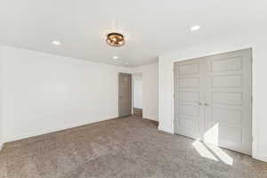 Unfurnished bedroom with recessed lighting, carpet floors, and a closet