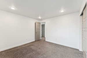 Unfurnished bedroom featuring carpet and baseboards