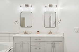 Grand Primary Bathroom with double vanity and a tub