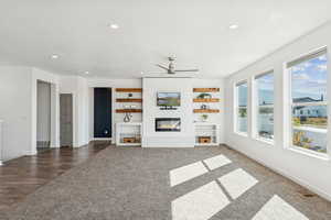 Unfurnished  great room with recessed lighting, medium  carpet, a fireplace, a ceiling fan, and built in features