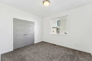 Unfurnished bedroom with a closet and carpet