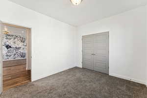 Unfurnished bedroom featuring carpet floors and a closet