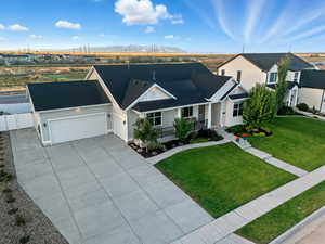 Welcome Home!View of front of property with a porch, a shingled roof, an attached garage, and concrete driveway