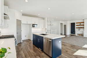 Kitchen featuring white cabinets, medium wood-type flooring, appliances with stainless steel finishes, blue cabinets, and recessed lighting