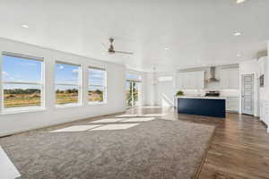 Unfurnished living room featuring recessed lighting, a ceiling fan, and medium wood finished floors