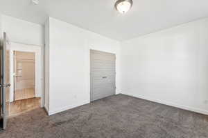 Unfurnished bedroom with carpet and a closet