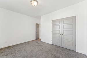 Unfurnished bedroom featuring carpet floors and a closet