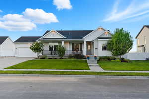 View of front of property with a porch, board and batten siding, concrete driveway, and an attached garage