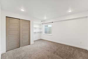 Unfurnished bedroom featuring light carpet, a closet, and recessed lighting