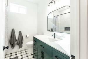 Full bath featuring vanity, curtained shower, and light tile patterned flooring