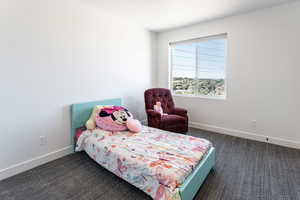 Bedroom with dark carpet and baseboards