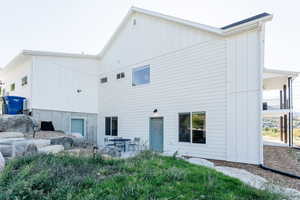 Rear view of house featuring board and batten siding and a patio