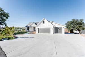 Modern inspired farmhouse with board and batten siding, concrete driveway, and a garage