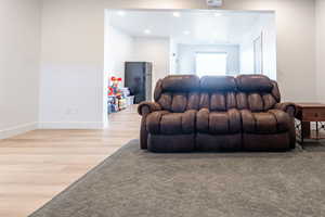 Living room with light wood-type flooring and recessed lighting