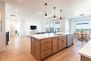 Kitchen featuring light brown cabinetry, pendant lighting, light wood-style floors, recessed lighting, and light stone countertops