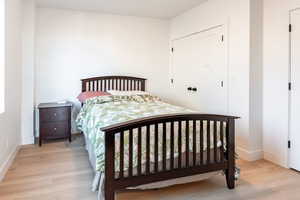 Bedroom with light wood finished floors and a closet