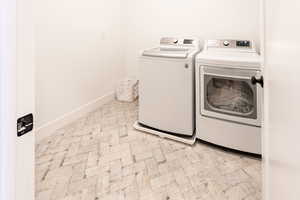 Washroom featuring baseboards and washer and clothes dryer