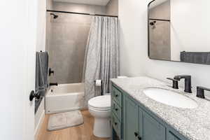 Full bath featuring shower / bath combination with curtain, light wood-style flooring, and vanity