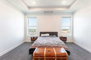 Bedroom featuring a tray ceiling, dark carpet, and recessed lighting