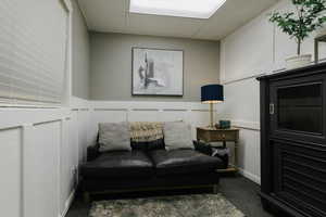Sitting room featuring a drop ceiling, a decorative wall, and a textured wall