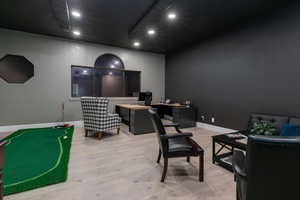 Office with light wood-type flooring and recessed lighting