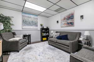 Living area featuring carpet flooring and a paneled ceiling
