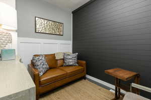 Living area featuring carpet and a decorative wall