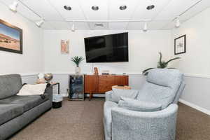 Carpeted living area with rail lighting